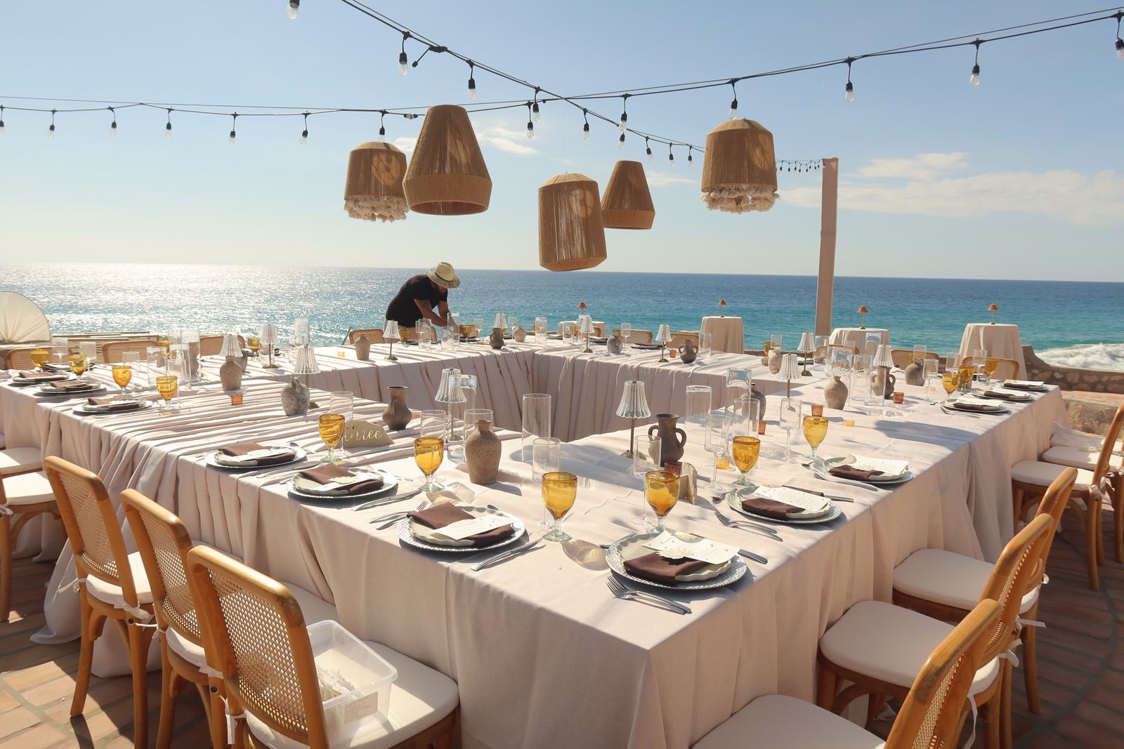 Dinner tables set on the terrace facing the ocean