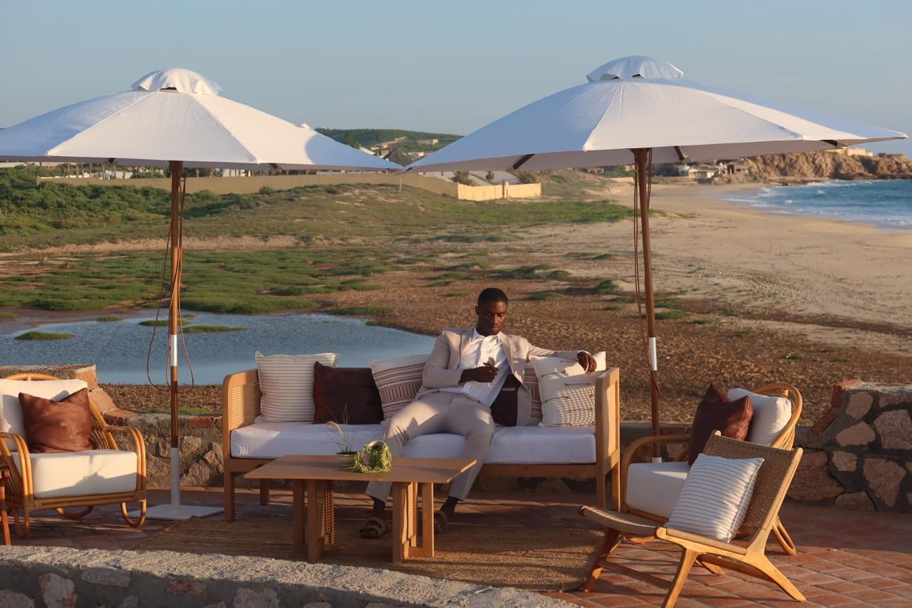 Lounge area under white umbrellas overlooking the beach and lagoon