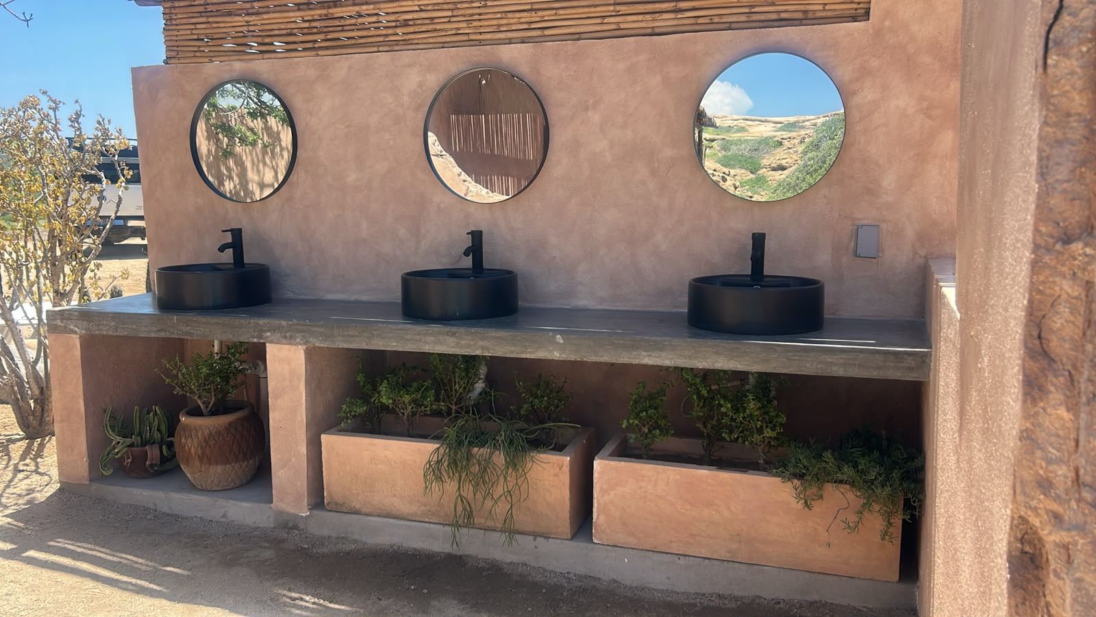 Restroom vanity with round mirrors and black basins