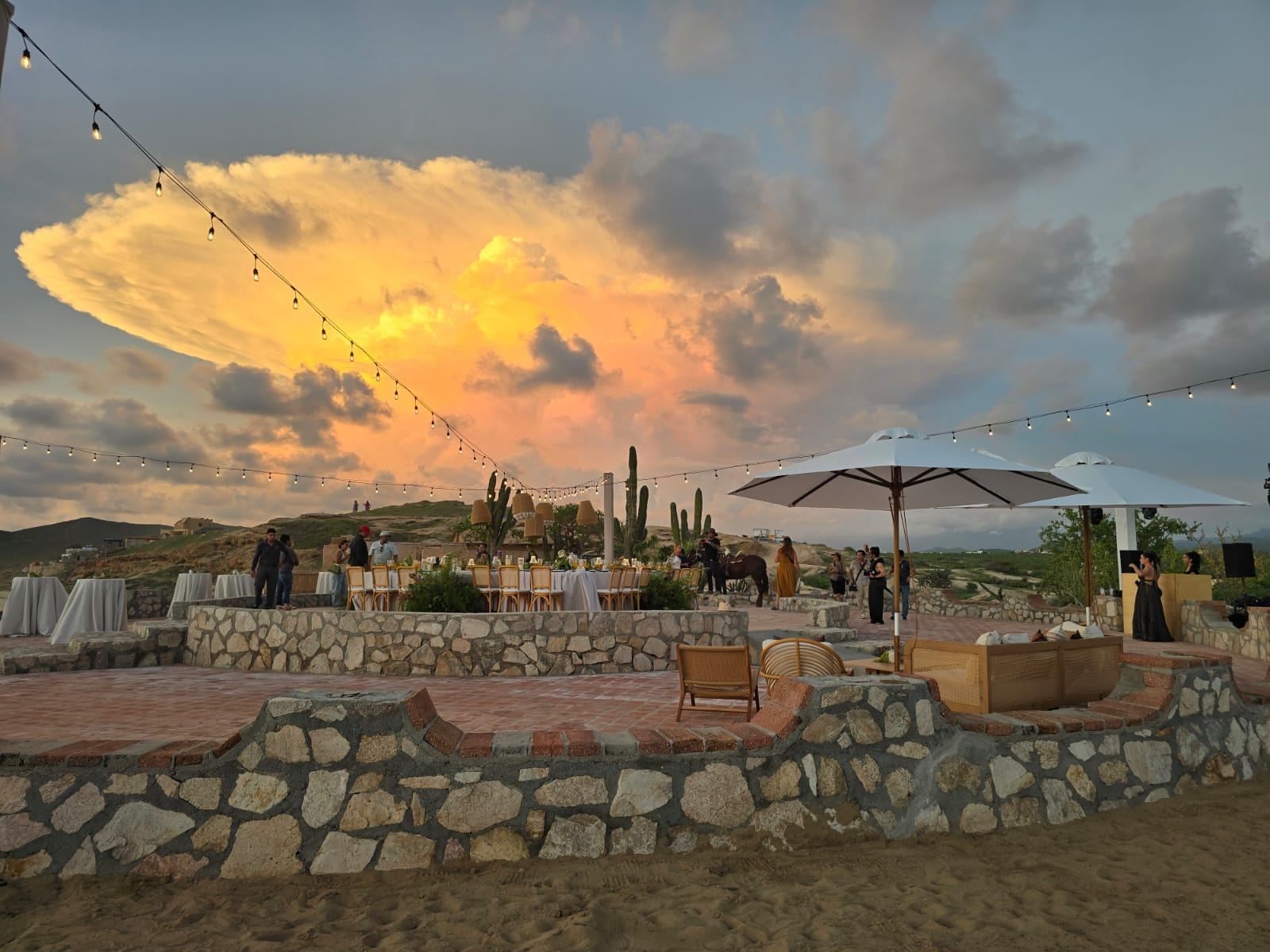 Stone terraces with string lights under a glowing evening sky